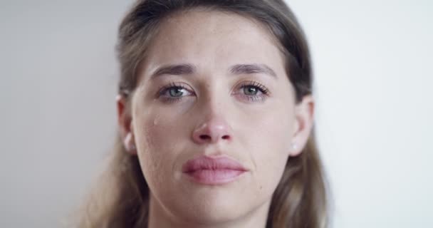 Depressed, crying and sad face of a woman looking alone and disappointed. Closeup of an emotional female suffering from PTSD and mental health issues, having a breakdown about bad news or a breakup. - Video