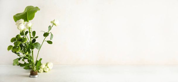 Beautiful ikebana on light background with space for text - Foto, imagen