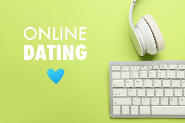 Computer keyboard, headphones and text ONLINE DATING on green background - Photo, image