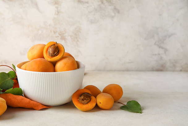 Bowl of tasty ripe apricots on light background - Foto, Imagem