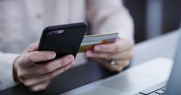 Hands shopping or banking online with a phone and laptop buying from a website. Closeup of female using her credit card spending on the internet and ordering from the web or app using ecommerce. - Filmmaterial, Video