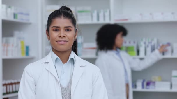 Pharmacist, healthcare worker or medical student doctor smiling in a pharmacy. Young, happy and cheerful clerk standing with medicine in a dispensary or storage in background for healing and wellness. - Video, Çekim