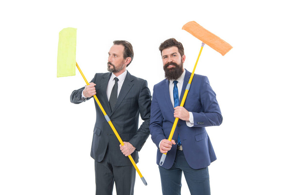 businessmen clear wall to white. Partnership and teamwork. cleaning company. clean business. clean slate. mature bearded men businessmen in formal suit hold householding mop. formal businessmen. - Zdjęcie, obraz