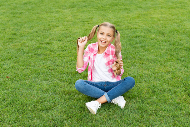glad teen child sit on green grass outdoor. - Valokuva, kuva