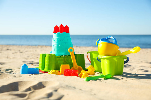 Different child plastic toys on sandy beach - 写真・画像