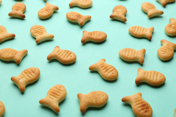 Delicious goldfish crackers on turquoise background, closeup - Fotoğraf, Görsel