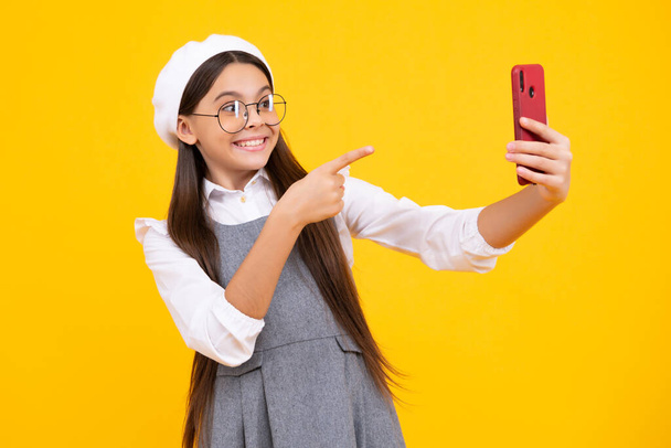 Kids selfie. Teenager child girl holding smartphone. Hipster girl with cell phone. Kid hold mobile phone texting in online social networks - Φωτογραφία, εικόνα