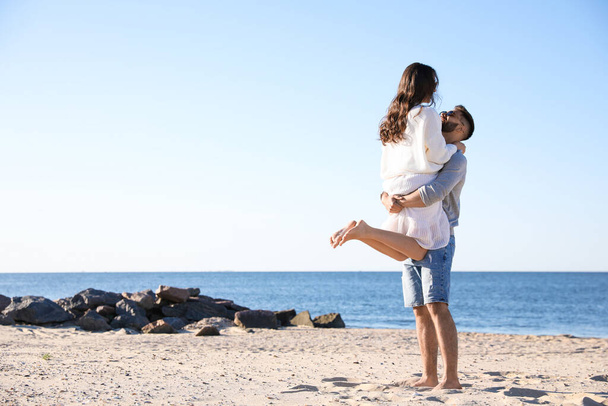Happy young couple on beach near sea. Honeymoon trip - Foto, imagen