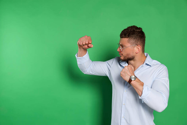 Young man ready to fight on green background, space for text - Photo, Image