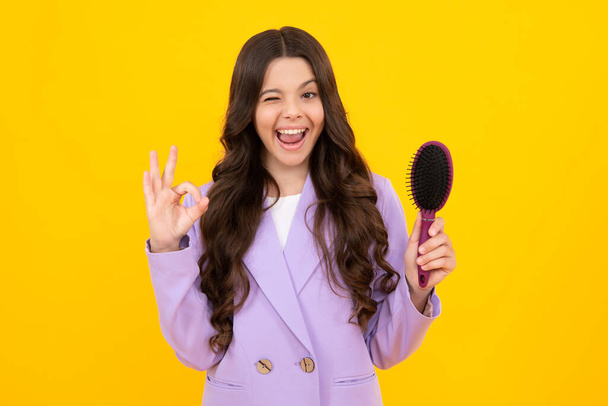 Child with long hair holding comb hairbrush for combing, beauty. Conditioner shampoo hair. Beauty kids salon. Child hairstyle. Excited teenager girl - Photo, image