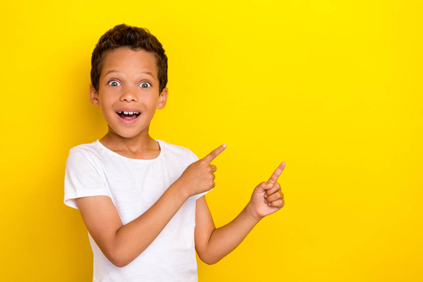 Photo of astonished boy impressed sale two arm direct empty space offer good shopping proposition isolated on yellow color background. - Fotoğraf, Görsel