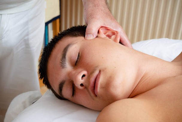 A Nineteen Year Old Teenage Boy Having A Head and Neck MAssage - Foto, Imagen
