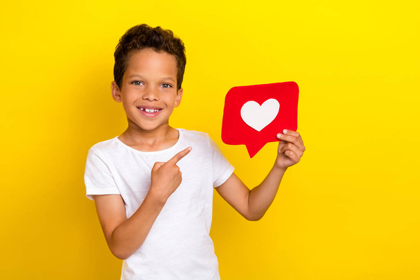Photo of lovely little boy index heart wear white t-shirt isolated on yellow color background. - Valokuva, kuva