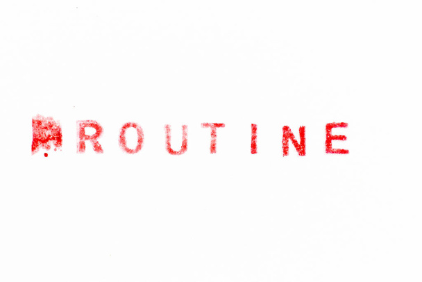 Красный цвет чернил резиновый штамп в рутине слова на белом бумажном фоне - Фото, изображение