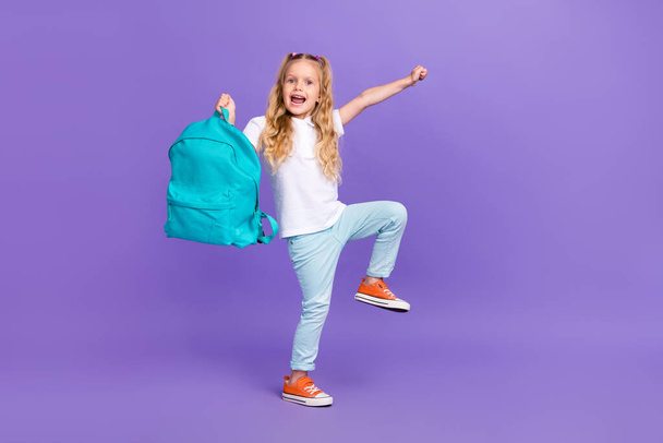 Full length photo of nice pupil girl ponytails smile buy new rucksack dressed stylish white outfit isolated on violet color background. - 写真・画像