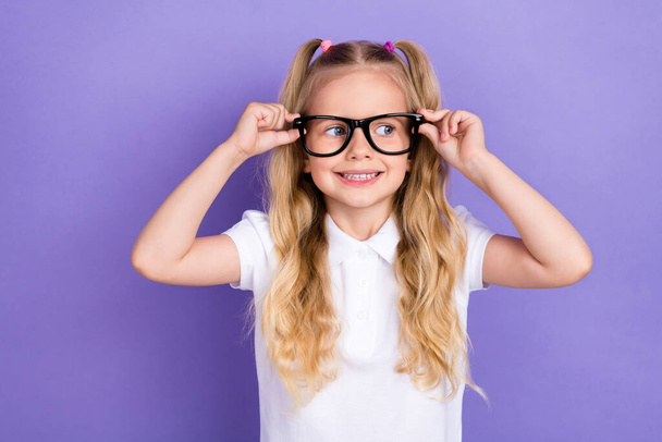 Photo of charming small girl tails arms touch eyewear oculist checkup dressed stylish white blouse isolated on violet color background. - Foto, imagen