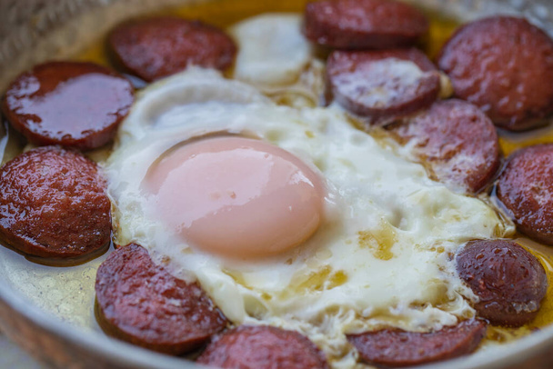 Turkse worst (worst) en eieren. Worst gebakken ei, ei met spek van bovenaf bekeken, worst met eiomelet. - Foto, afbeelding