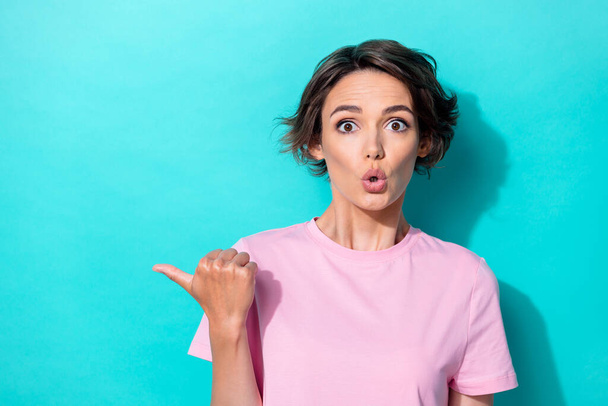 Photo of impressed short hairdo millennial lady index empty space wear pink t-shirt isolated on turquoise color background. - Foto, afbeelding