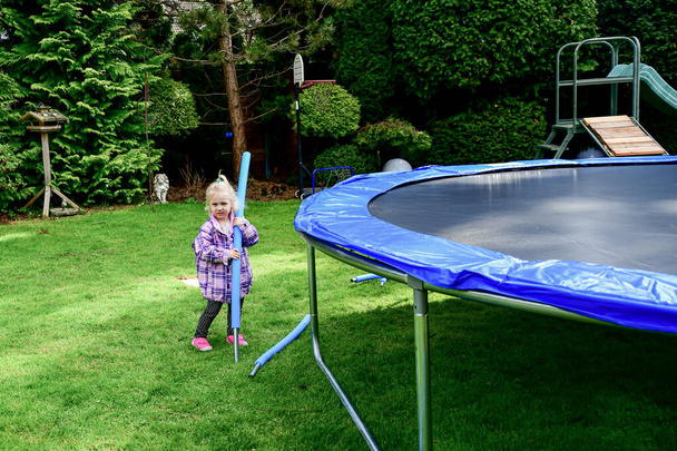 Children collect a disassembled trampoline in the yard after purchase. - Foto, Bild