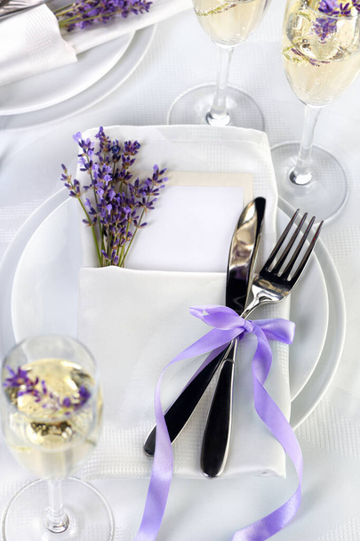 Dining table in Provence style, with Lavender Champagne, folded napkin with cutlery, decorated with fresh lavender. Detail of the wedding dinner. Wedding theme ideas. - Valokuva, kuva