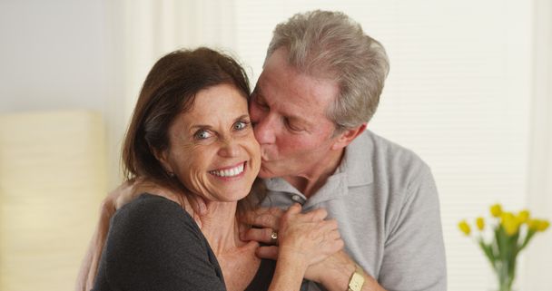 Roztomilý starší pár s úsměvem a při pohledu na fotoaparát - Fotografie, Obrázek
