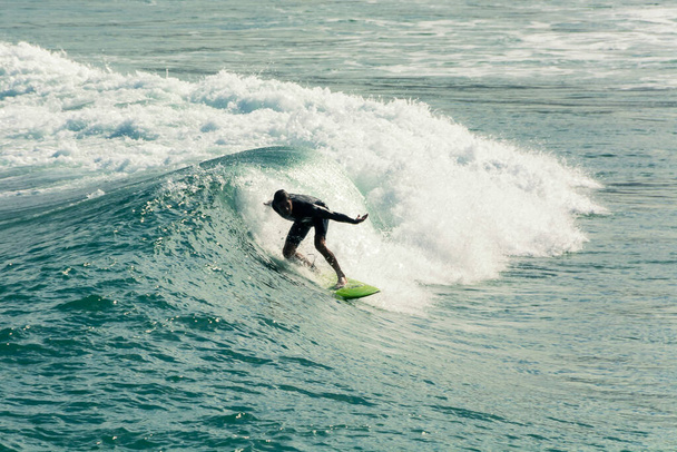 Ipanema Beach, Rio de Janeiro, Brazil. May 25, 2022: Surfer riding a wave at the beach in Rio de Janeiro, Brazil. - Фото, изображение