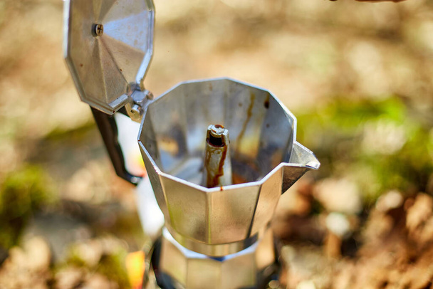 Making camping coffee from a geyser coffee maker on a gas burner,, autumn outdoor. Male prepares coffee outdoors, travel activity for relaxing, bushcraft, adventure, travel, tourism and camping concept - Foto, Imagen