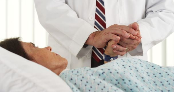 Arts die van patiënt hand en troostend haar - Foto, afbeelding