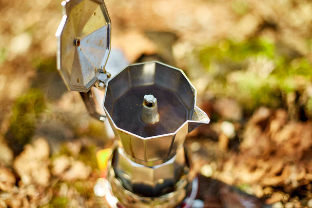 Making camping coffee from a geyser coffee maker on a gas burner,, autumn outdoor. Male prepares coffee outdoors, travel activity for relaxing, bushcraft, adventure, travel, tourism and camping concept - Foto, Bild