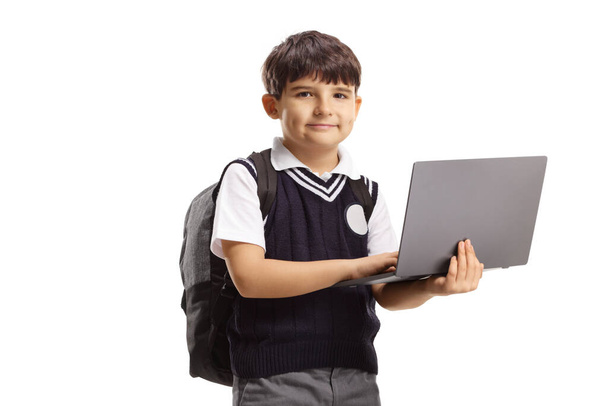 Boy in a school uniform holding a laptop computer isolated on white background - Valokuva, kuva