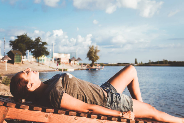 Вид расслабленной женщины, лежащей на шезлонге на пляже. - Фото, изображение