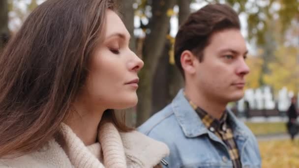 Caucasian girl offended by male lover on background young family couple standing outdoors ignoring each other looking different ways conflict misunderstanding sad woman thinking breakup with boyfriend - Video