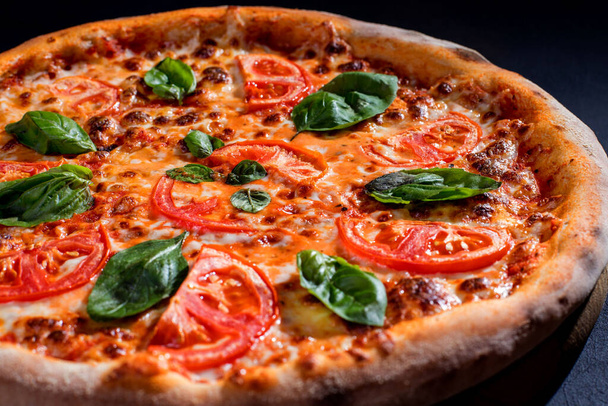 Delicious fragrant pizza with mozzarella, tomatoes and basil with tomato sauce - Margherita. - Foto, Bild