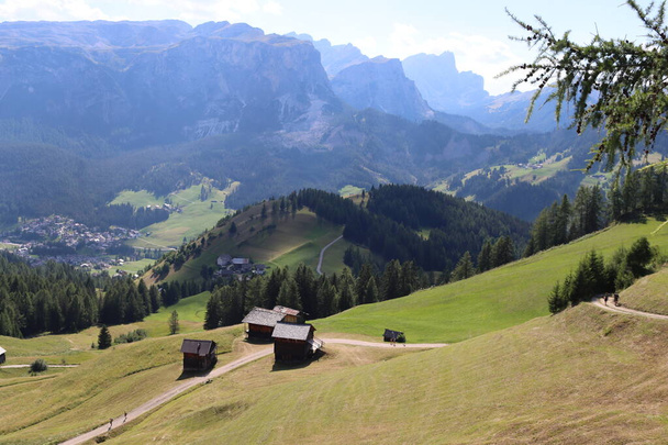 Val Badia, Italy-July 17, 2022: The italian Dolomites behind the small village of Corvara in summer days with beaitiful blue sky in the background. Green nature in the middle of the rocks. - Zdjęcie, obraz