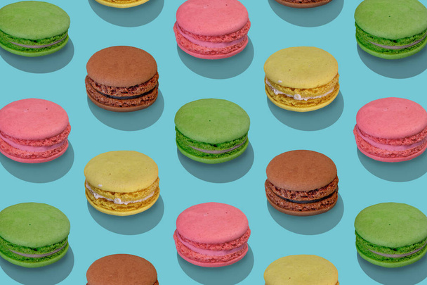 Beautiful composition from large group of french macarons on blue background. Flat lay, top view. Isometric view. - Foto, Imagen