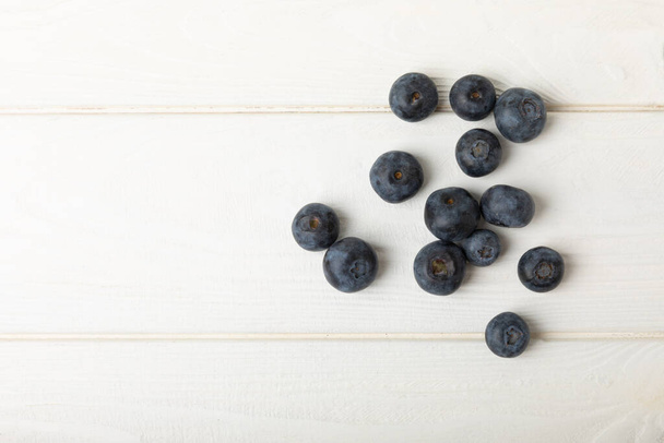 Blueberries on white textured background. Ripe and fresh blueberries. Vitamins. Healthy food. Juicy berry.Copy space.Place for text - Photo, Image