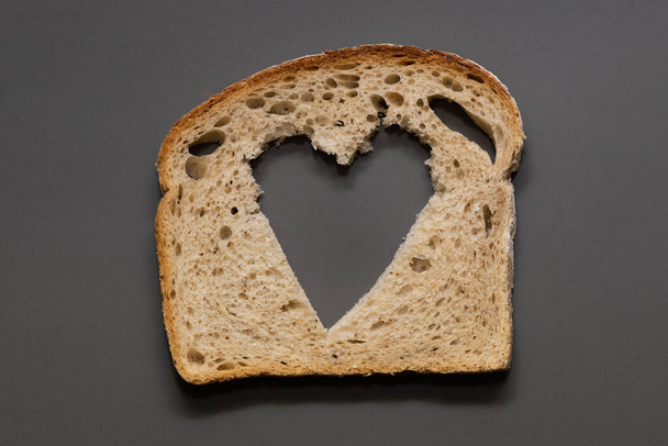 Rye bread bread slice with heart shaped hole - Fotoğraf, Görsel