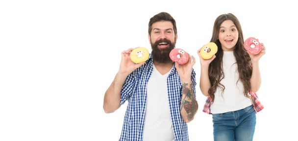 Baked donuts with smiley faces. Happy family holding home baked snack. Hipster and small girl child smiling with freshly baked and glazed dessert. Bearded man and little daughter with baked doughnuts. - Photo, Image