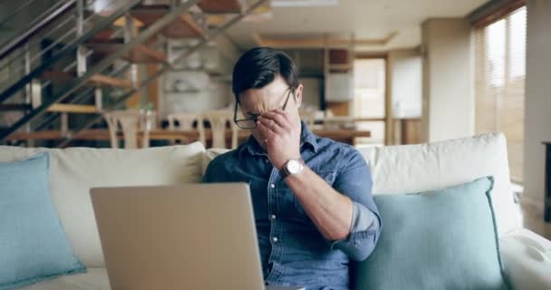 Man suffering from painful headache or migraine while typing on laptop, browsing internet or streaming videos online. Tired, stressed and unhappy guy feeling pain, sending email or watching movies. - Filmati, video