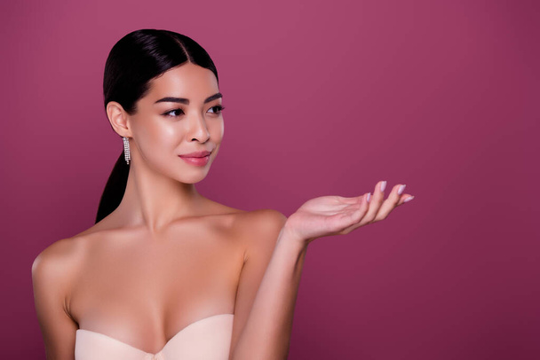 Portrait of lovely lady demonstrate new skin body care treatment on pink color empty space background stand isolated. - Foto, Imagen