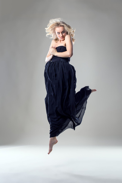 Beautiful blonde dancer posing in jump - Foto, imagen