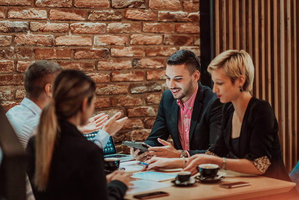 Happy businesspeople smiling cheerfully during a meeting in a creative office. Group of successful business professionals working as a team in a multicultural workplace. High quality photo - Fotoğraf, Görsel