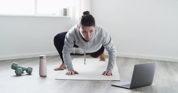 Fitness, exercise and healthy woman training at home doing spiderman pushups in her workout routine on a mat to get a stronger upper body. Young female athlete exercising to active tutorial videos. - Séquence, vidéo