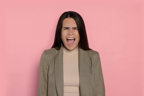 Aggressive young woman shouting on pink background - Foto, immagini