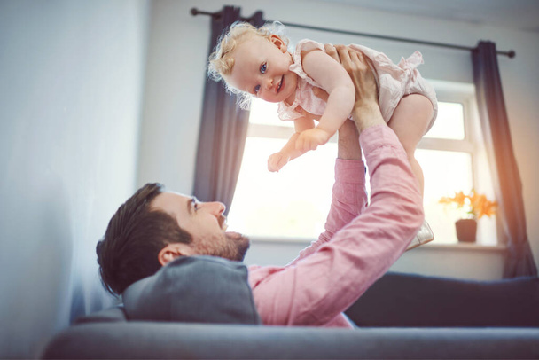 Коли я щасливий, татусі щасливі. молодий чоловік проводить якісний час зі своєю чарівною донькою вдома
 - Фото, зображення
