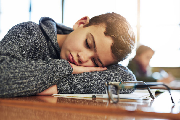 Hes had a long day at school. an elementary schoolboy taking a nap in class - Foto, immagini