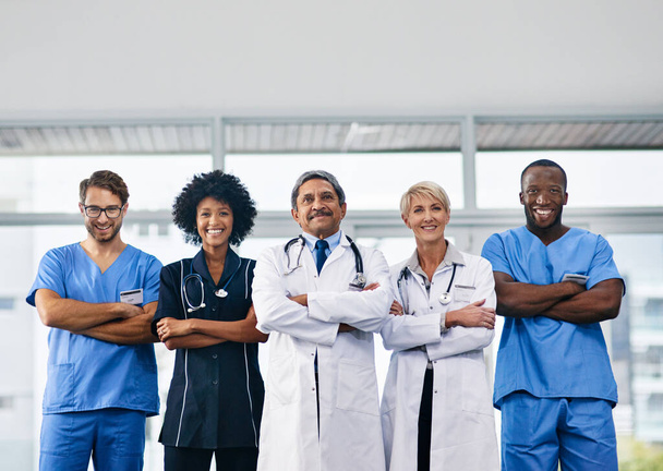 Ваше здоровье наш приоритет. Портрет разноплановой команды врачей, стоящих вместе в больнице - Фото, изображение