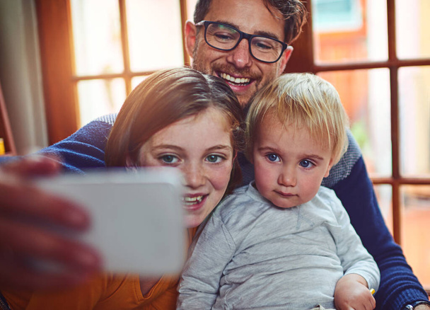 Our happy family. a father taking a selfie with his little son and daughter at home - Photo, image