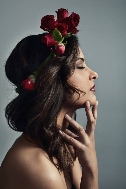 As delicate as a rose but as strong as thorns. Studio shot of a beautiful young woman wearing a floral head wreath against a grey background - Foto, imagen