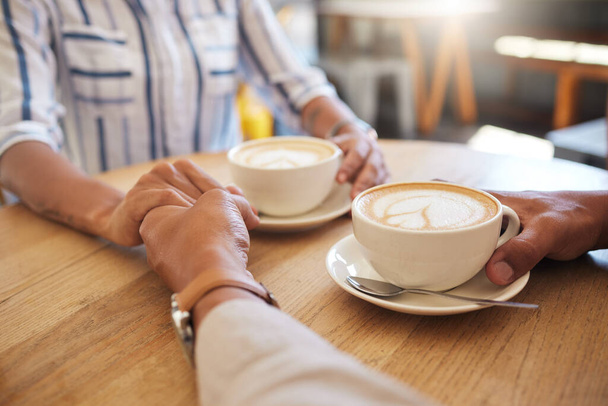 Καφές, διάλειμμα και χρονολόγηση ζευγάρι κρατώντας τα χέρια σε μια ρομαντική ημερομηνία σε ένα καφέ, εστιατόριο ή καφετέρια. Άνδρας, γυναίκα ή άνθρωποι που αγγίζουν, στην αγάπη και το ειδύλλιο την επέτειο ή ημέρα του Αγίου Βαλεντίνου μαζί. - Φωτογραφία, εικόνα
